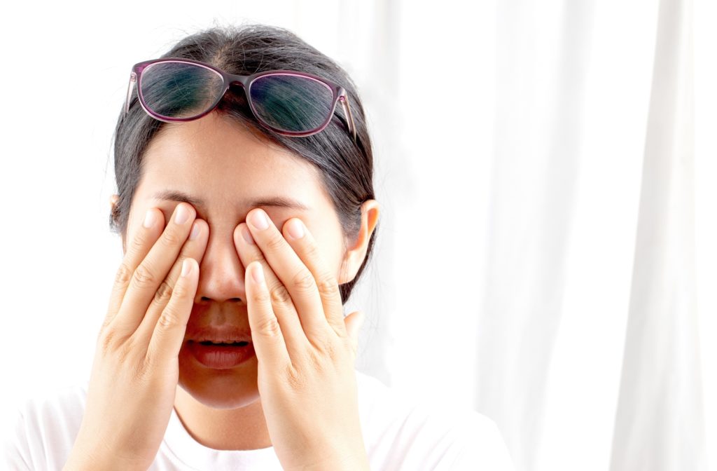 A woman rubbing her dry eyes.
